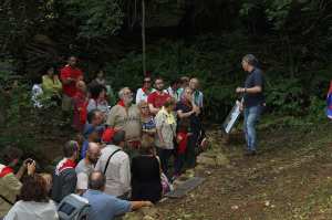 Franco Rasia illustra ad un gruppo di visitatori il rifugio che è proprio sotto i suoi piedi.